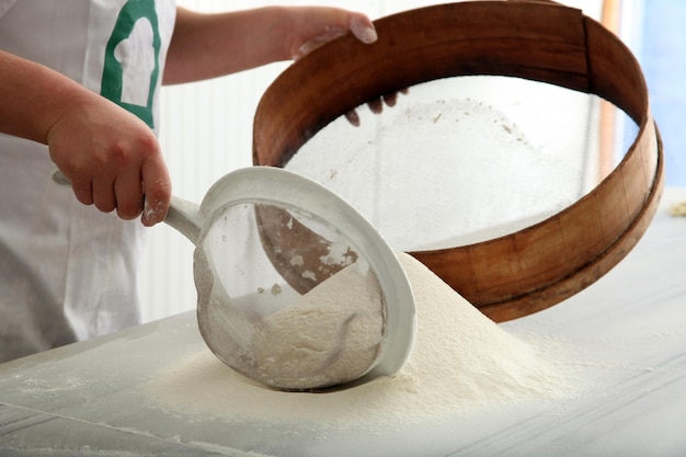 Chef sifting flour for bread making