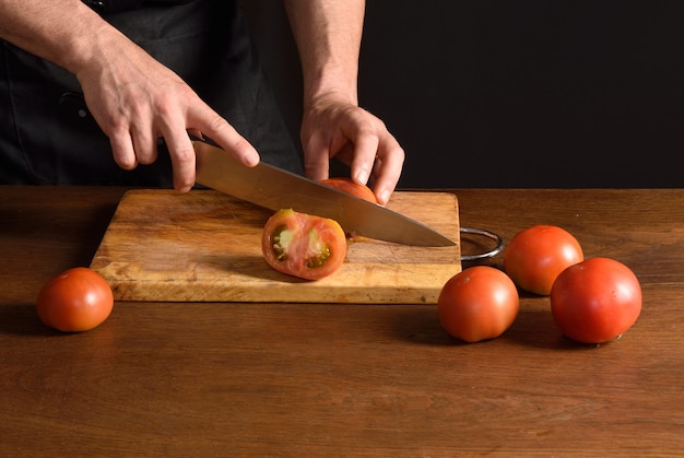 Chef slicing tomato