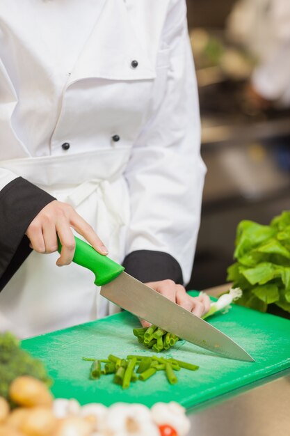 Chef slicing up scallions