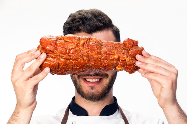 Chef smiles and closes his eyes with a piece of fresh ham