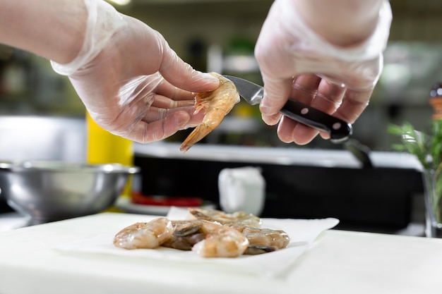 Chef snijdt de garnaal Concept van de mediterrane keuken