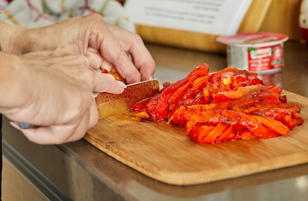 Chef snijdt paprika in plakjes om gerecht te bereiden volgens recept van internet