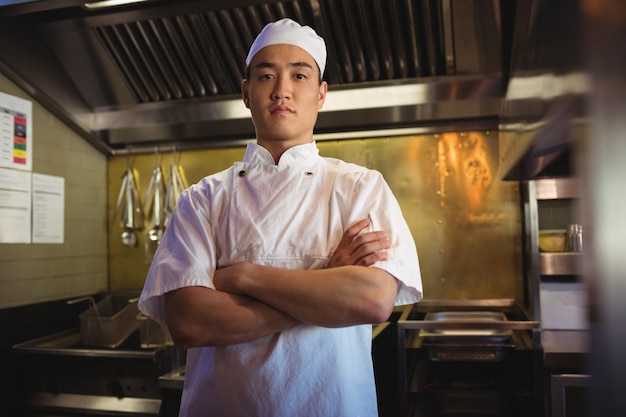 Chef standing with arms crossed in the commercial kitchen