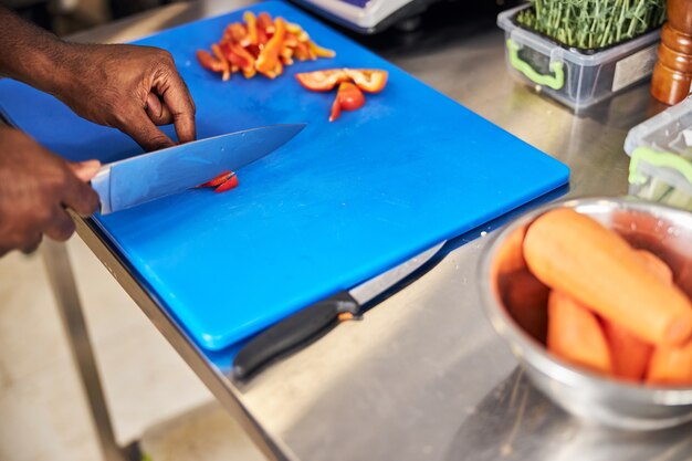 トマトとニンジンの詰め物を調理し、準備するためにナイフを使用するシェフ