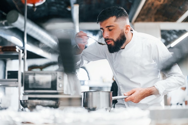 Chef in white uniform cooking food at kitchen Busy day at work