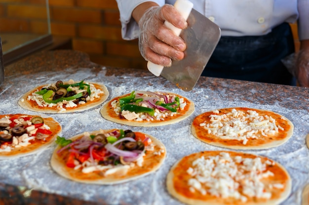 The chef, who puts toppings on a pizza