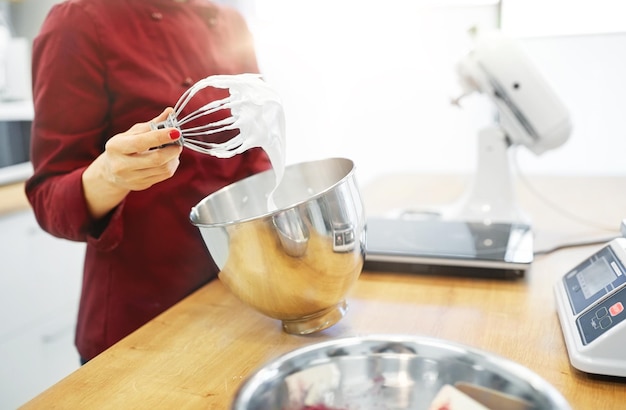 chef with whisk and whipped egg whites at kitchen