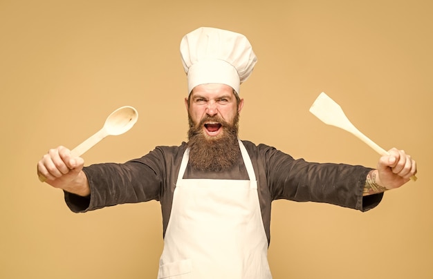 Chef con cucchiaio di legno che cucina cucina pubblicità utensili da cucina chef barbuto