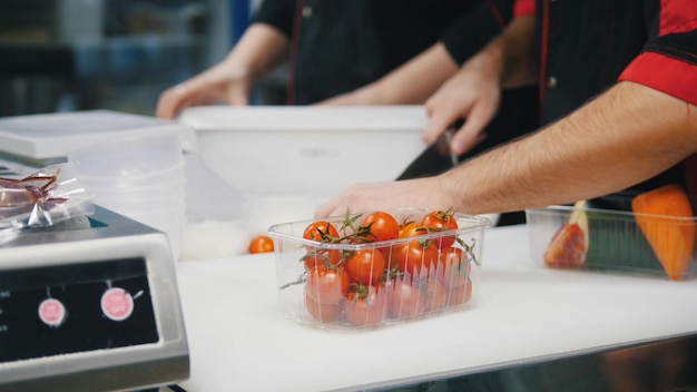 A chef working in the kitchen cherry tomatoes in the package