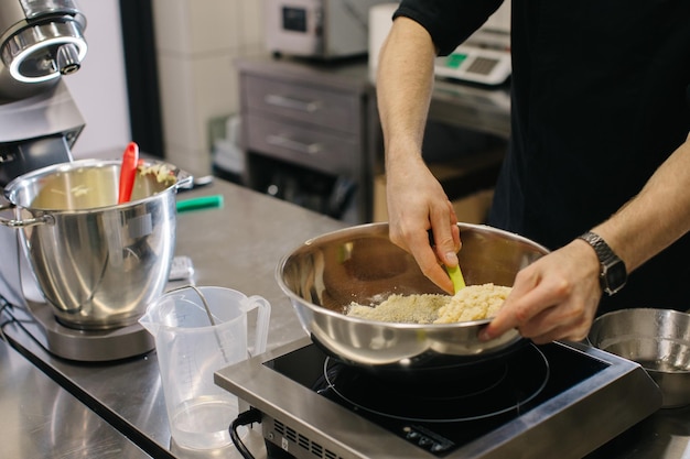 Lo chef lavora in cucina il processo di preparazione dell'impasto per amaretti