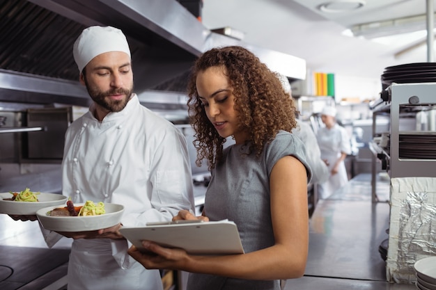 Chefs discussing menu on clipboard