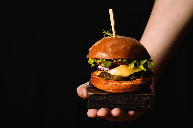 Chefs hand serving fresh burger