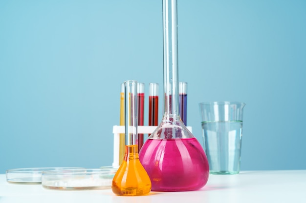 Фото Химическая лабораторная посуда с различными цветными жидкостями на столе