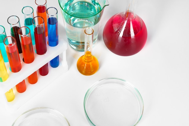 テーブルの上のさまざまな色の液体の化学実験用ガラス器具
