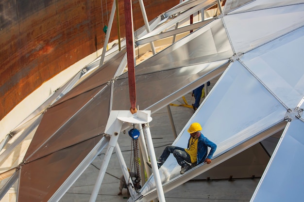 L'industria del lavoratore di sesso maschile di petrolio e gas chimico con serbatoio di stoccaggio del tetto superiore in alluminio a cupola.