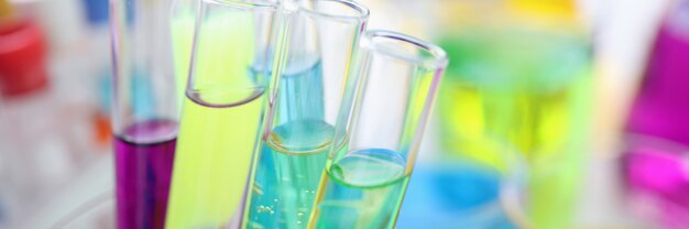 Chemical test tubes with multicolored liquid on desktop in laboratory scientific work and