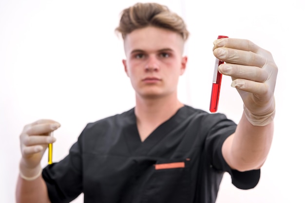 Chemie en laboratorium experiment concept. Man in medisch uniform en beschermende handschoenen met rode reageerbuis