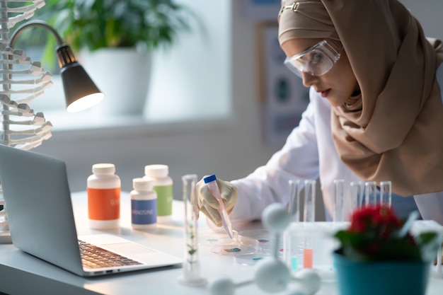 Chemisch laboratorium. vrouw met hijab die in het chemisch laboratorium werkt en chemische middelen bestudeert