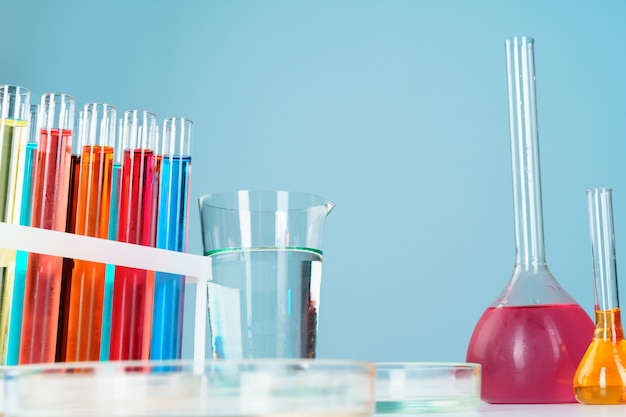 Chemisch laboratoriumglaswerk met verschillende gekleurde vloeistoffen op tafel