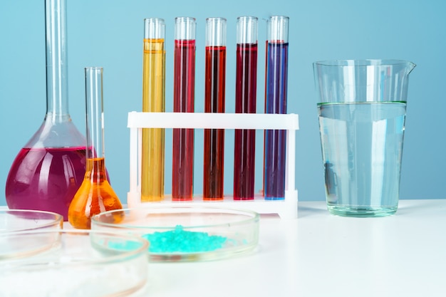Chemisch laboratoriumglaswerk met verschillende gekleurde vloeistoffen op tafel