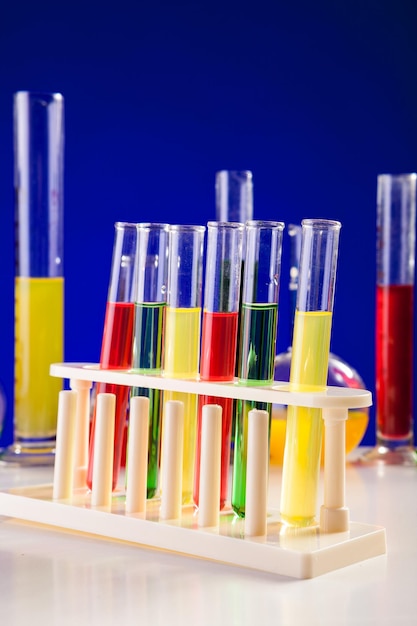 Chemische laboratoriumapparatuur op een tafel op een blauwe achtergrond. Glaswerk en biologie apparatuur