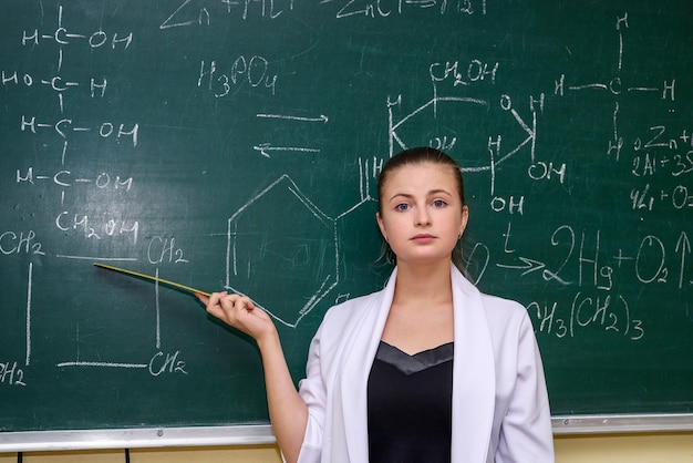 Chemische opleiding. Vrouw in de buurt van bord die studenten wat materiaal uitlegt