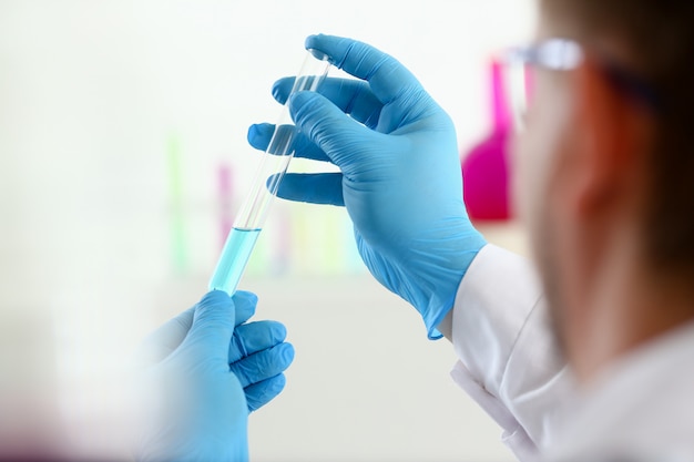 chemist holds test tube of glass in