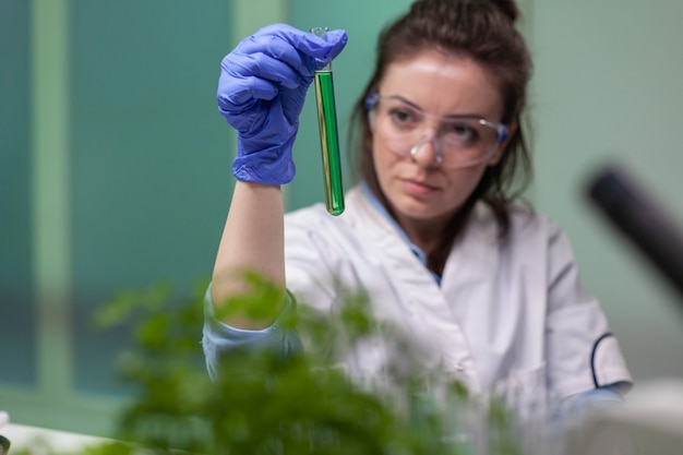 Chemist researcher woman holding test tube with dna liquid