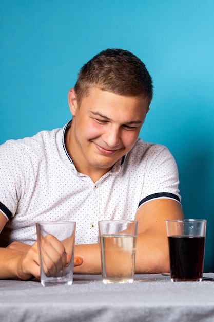 Educazione chimica e concetto di studio. uomo scienziato versare acqua in un bicchiere con elementi chimici, per esperimenti a casa