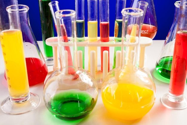 Chemistry lab set on a table over blue background. Glassware and biology equipment