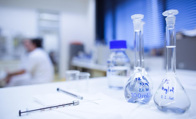 Chemistry lab shallow DOF focus on the glassware in the foregr