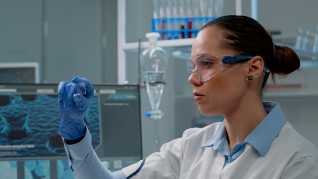 Chemistry specialist analyzing blood sample on glass