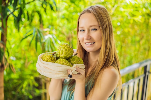 Cherimoya in a reusable bag in female hands Zero waste concept plastic free concept Healthy clean eating diet and detox Summer fruits