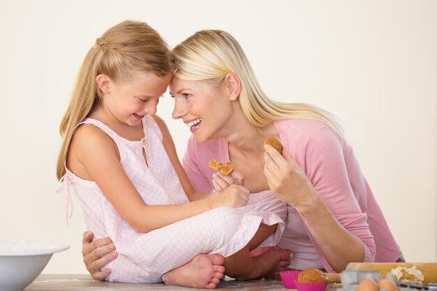 Cherishing every moment with her A mother and daughter eating muffins after baking and bonding