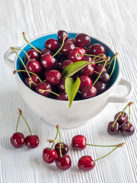 Cherries in a bowl on wooden background