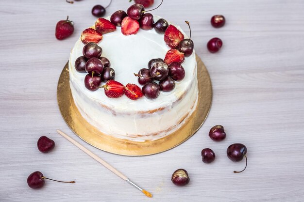 Cherries and strawberries with edible gold on top of cheesecake with coconut