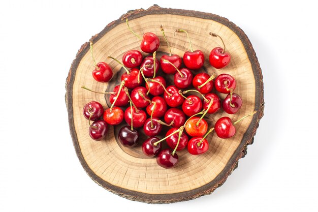 Cherries on wood slice isolated on white background