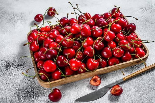 Cherries in a wooden bowl. fresh ripe cherries on gray. Top view