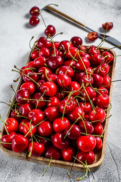 Cherries in a wooden bowl on gray