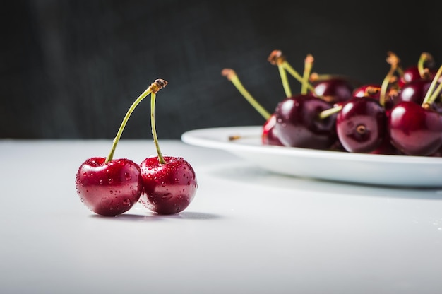 Cherries on a wooden table with water drops macro background