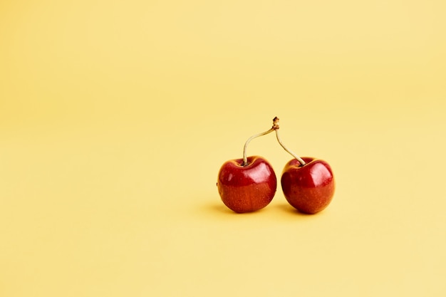 Cherries on yellow surface copy space