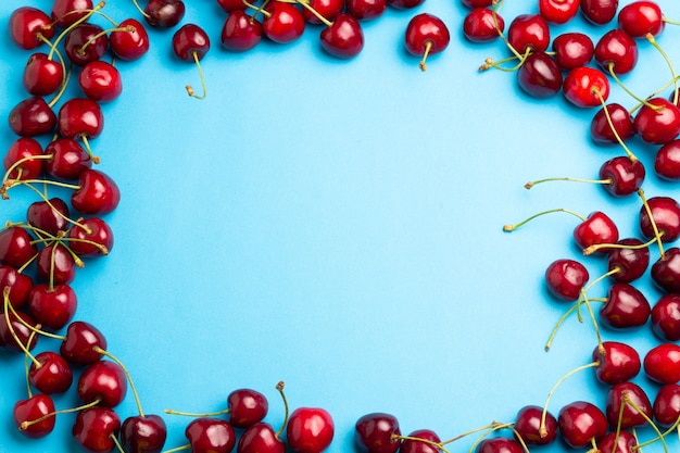 Cherry berries border on a blue background top view