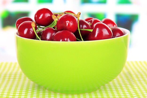 Cherry berries in bowl on table in room