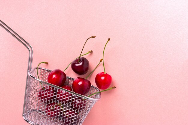 Photo cherry berries in a steel mini basket