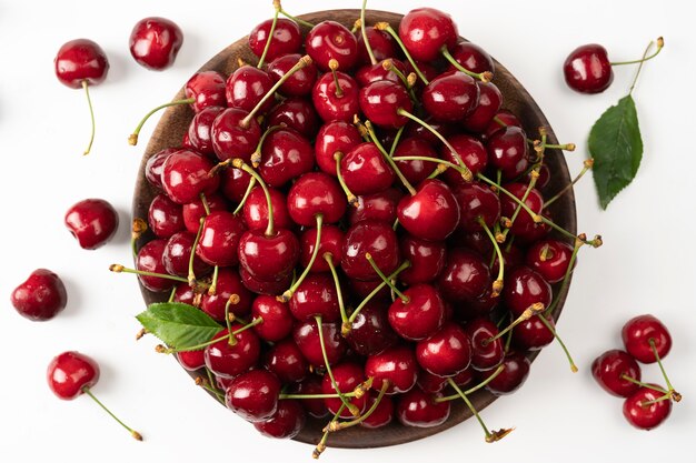 Cherry berries in wooden bowl isolated on white background sweet cherries top view red cherry on white background