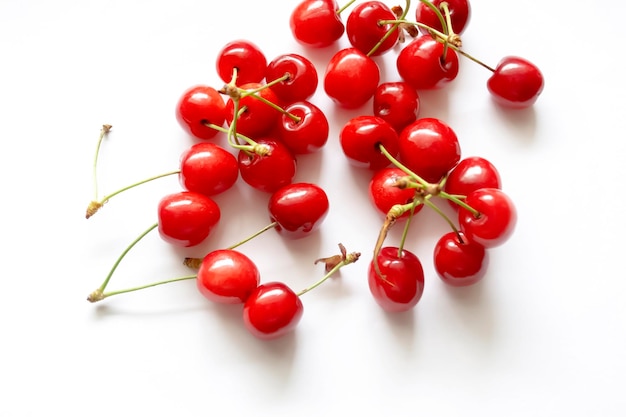 Cherry bessen op een witte achtergrond Geïsoleerde rode kersen Veel rode kersen met groene staarten op wit