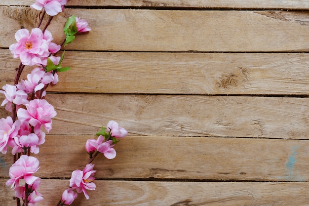 Cherry blossom and Artificial flowers on vintage wooden background with copy space.