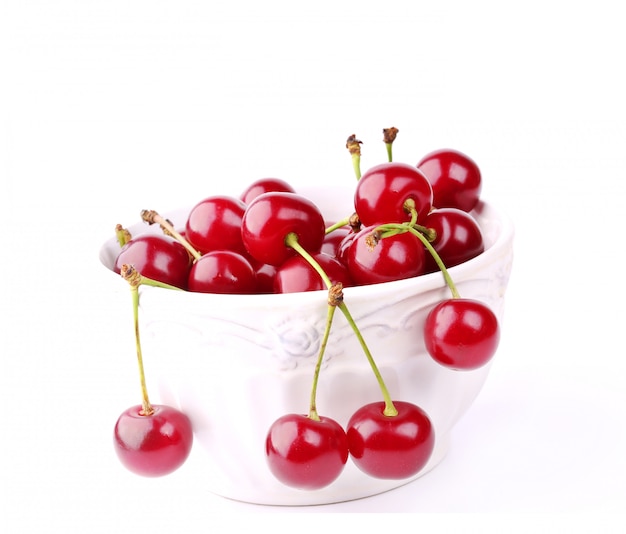 Cherry in ceramic bowl isolated on white background