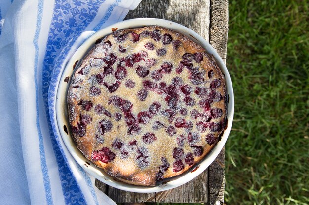 체리 clafoutis. 소박한 배경에 만든 체리 파이