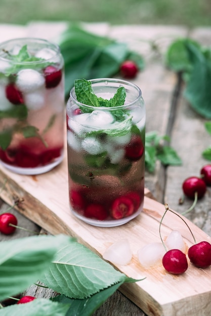 Cherry cocktail with ice and mint in a glass